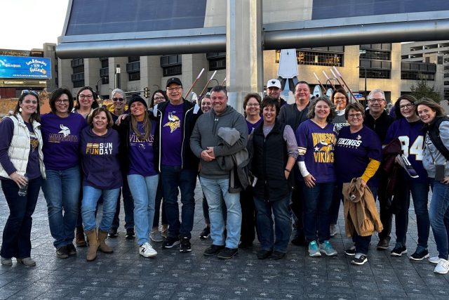 Staff of First State Bank standing in US Bank Stadium Plaza